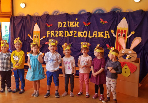 Na zdjęciu dzieci z grupy drugiej. W tle granatowy materiał z napisem dzień przedszkolaka